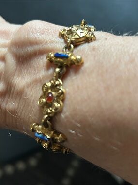 Arthur Pepper gold tone with blue and red stones.